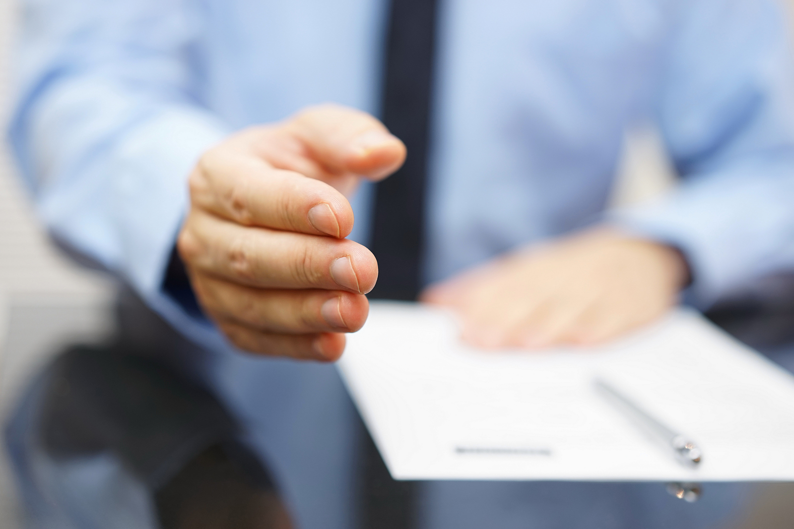 Businessman offering a handshake and contract to sing